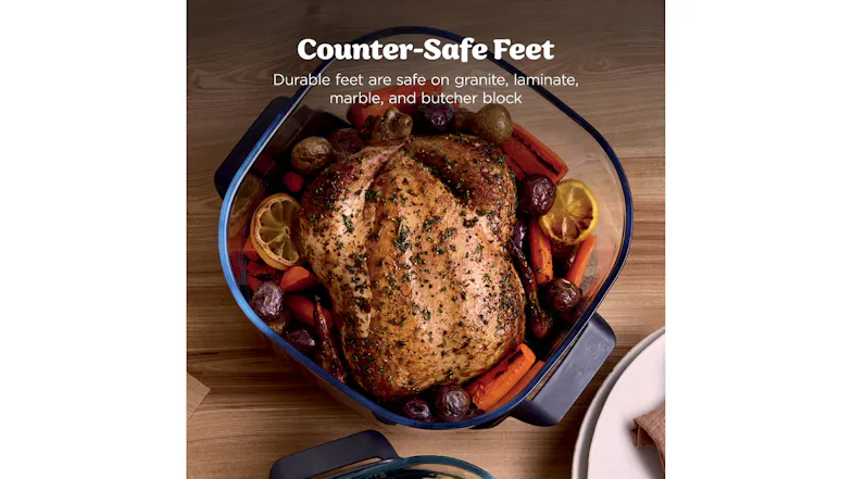 Top-down view of a roasted chicken inside the glass container Top-down view of a roasted chicken inside the glass container