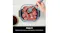 Close-up view of a person marinating food, showcasing the Ninja container with raw meat Close-up view of a person marinating food, showcasing the Ninja container with raw meat