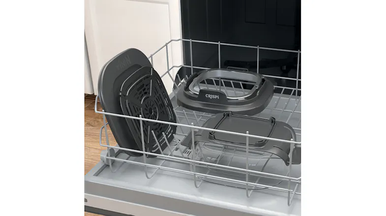 High-angle view of the Ninja container parts arranged inside an open dishwasher rack High-angle view of the Ninja container parts arranged inside an open dishwasher rack