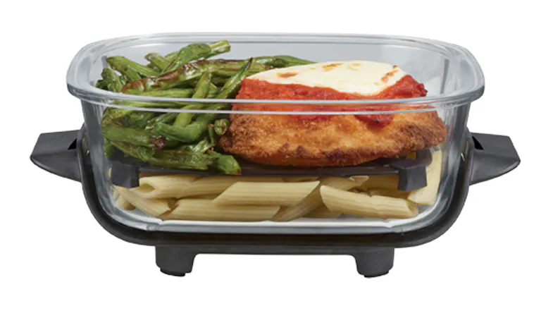 Close-up view of a glass container with chicken parmigiana and pasta Close-up view of a glass container with chicken parmigiana and pasta