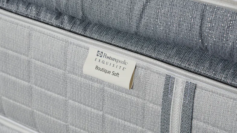 Detail of the fabric texture and the Sealy Posturepedic Boutique Soft label on the side of a king mattress Detail of the fabric texture and the Sealy Posturepedic Boutique Soft label on the side of a king mattress