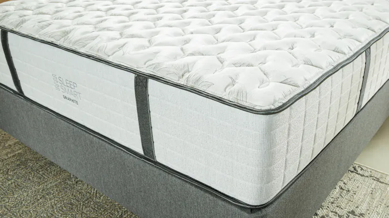 Sleep Smart Graphite mattress with quilted top, grey sides, and dark handles on a matching grey bed base Sleep Smart Graphite mattress with quilted top, grey sides, and dark handles on a matching grey bed base