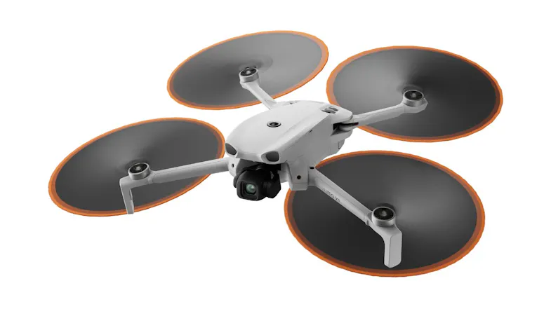 A compact DJI Mini camera drone with spinning propellers, ideal for smooth aerial video and travel use A compact DJI Mini camera drone with spinning propellers, ideal for smooth aerial video and travel use