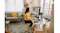 A woman at a white desk is editing a photo on a monitor with a camera A woman at a white desk is editing a photo on a monitor with a camera