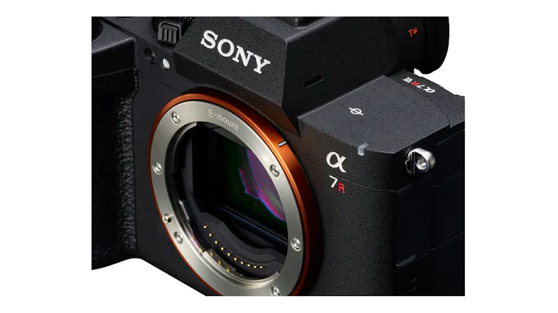 A close-up, dynamic, high-angle view looking down at the silver and orange ringed E-mount camera lens mount A close-up, dynamic, high-angle view looking down at the silver and orange ringed E-mount camera lens mount