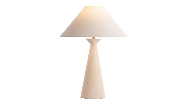 White table lamp with a tall, tapered base and wide fabric shade, softly illuminated White table lamp with a tall, tapered base and wide fabric shade, softly illuminated