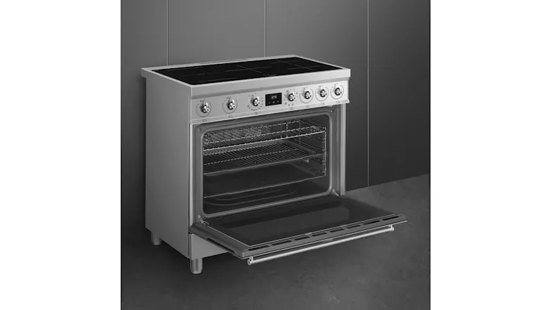 Open stainless steel Smeg oven at an angle, showing interior racks, a tray, and a glass door folded down Open stainless steel Smeg oven at an angle, showing interior racks, a tray, and a glass door folded down