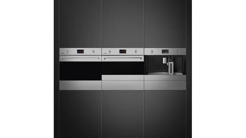 Modern kitchen wall with built-in stainless steel ovens and an integrated coffee machine in dark cabinetry Modern kitchen wall with built-in stainless steel ovens and an integrated coffee machine in dark cabinetry