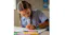 A girl drawing at a desk, showcasing the smartwatch on her wrist A girl drawing at a desk, showcasing the smartwatch on her wrist