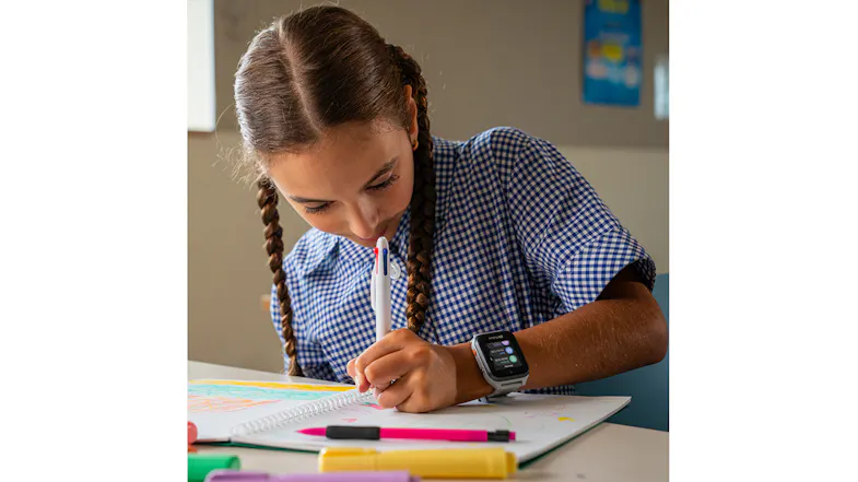 A girl drawing at a desk, showcasing the smartwatch on her wrist A girl drawing at a desk, showcasing the smartwatch on her wrist