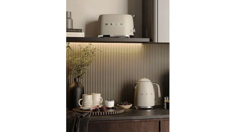 A view of the Smeg 50s style kettle and toaster in matte moonlight displayed in a dimly-lit room A view of the Smeg 50s style kettle and toaster in matte moonlight displayed in a dimly-lit room