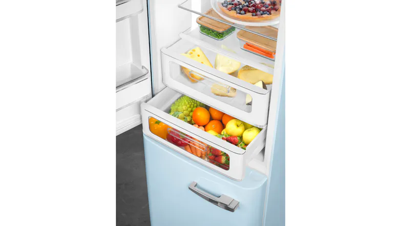 Bottom fridge drawers of SMEG with apples, citrus fruits, berries, and cheese in clear compartments Bottom fridge drawers of SMEG with apples, citrus fruits, berries, and cheese in clear compartments