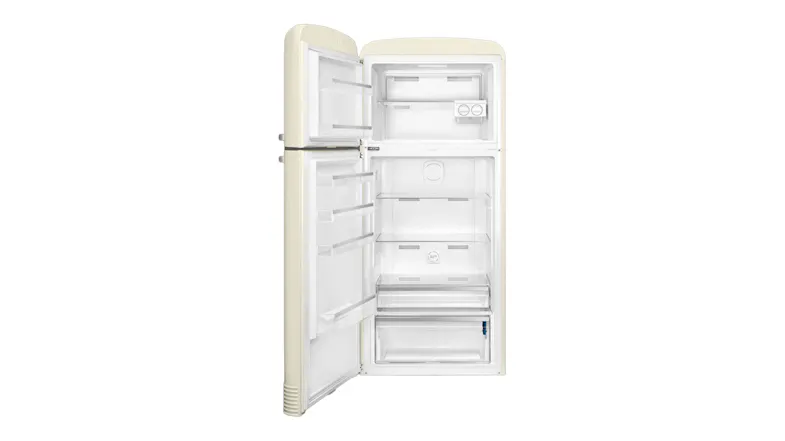 An open cream Smeg refrigerator showing the clean white interior shelves, door bins, and drawers An open cream Smeg refrigerator showing the clean white interior shelves, door bins, and drawers