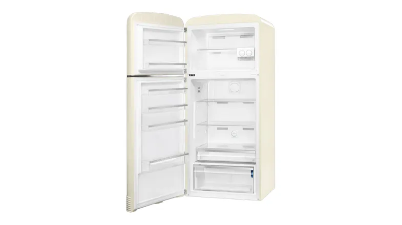 Angled view of an open cream Smeg refrigerator displaying spacious white compartments and door shelving Angled view of an open cream Smeg refrigerator displaying spacious white compartments and door shelving