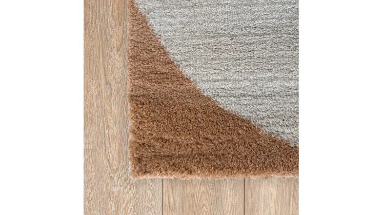 Angled close-up of the rug edge on a wooden floor, highlighting the contrast Angled close-up of the rug edge on a wooden floor, highlighting the contrast