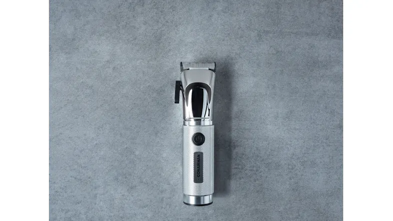 Top-down view of a cordless hair clipper featuring stainless steel blades and a textured silver handle Top-down view of a cordless hair clipper featuring stainless steel blades and a textured silver handle