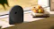 Sunny patio scene highlighting a black speaker near a bowl of fruit Sunny patio scene highlighting a black speaker near a bowl of fruit