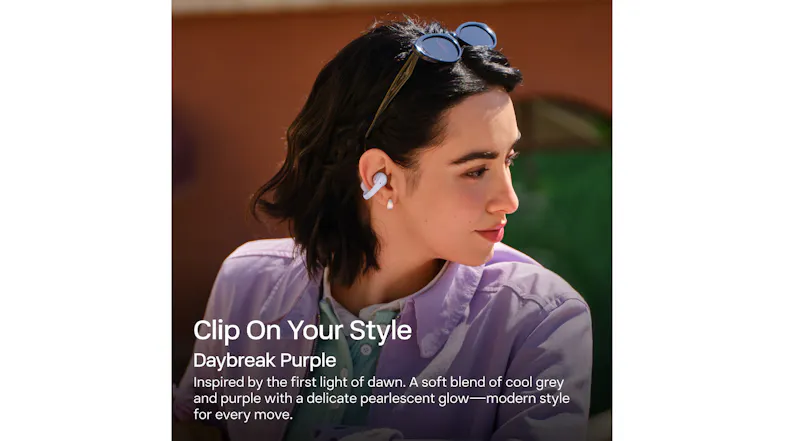 Profile view of a person wearing purple earbuds outdoors Profile view of a person wearing purple earbuds outdoors