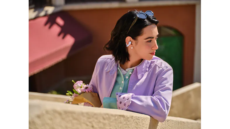 A person wearing an earbud with a matching jacket outdoors A person wearing an earbud with a matching jacket outdoors