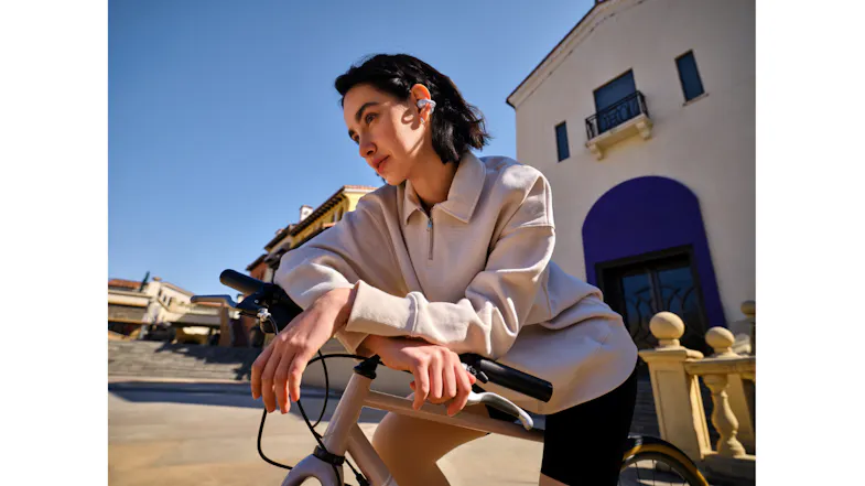 Front view of a person sitting on a bicycle while wearing an earbud Front view of a person sitting on a bicycle while wearing an earbud
