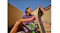 Low-angle view of a person holding a skateboard outdoors with earbuds Low-angle view of a person holding a skateboard outdoors with earbuds