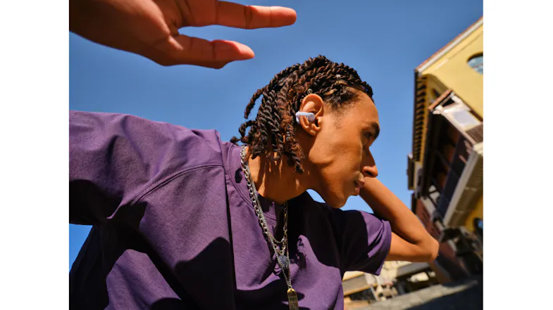 Dynamic angle view of a person wearing earbuds under sunlight Dynamic angle view of a person wearing earbuds under sunlight