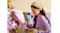Close-up view of a woman painting a floral canvas artwork with matching earbuds Close-up view of a woman painting a floral canvas artwork with matching earbuds
