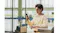 Lifestyle view of a man looking at his phone indoors while wearing earbuds Lifestyle view of a man looking at his phone indoors while wearing earbuds