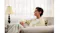 Indoor lifestyle view of a man with an earbud relaxing on a sofa Indoor lifestyle view of a man with an earbud relaxing on a sofa