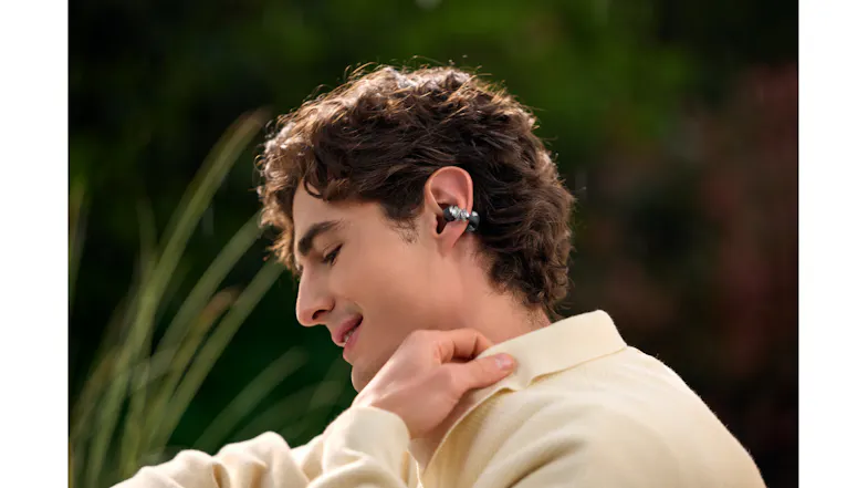 Close-up view of a man smiling while wearing an earbud Close-up view of a man smiling while wearing an earbud