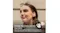 Profile view of a person standing near a building wall with an earbud Profile view of a person standing near a building wall with an earbud