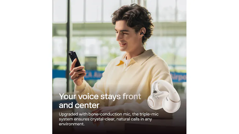 High-angle view of a man with an earbud looking at his phone indoors High-angle view of a man with an earbud looking at his phone indoors