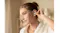 Close-up view of a woman adjusting her earbud indoors Close-up view of a woman adjusting her earbud indoors