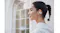 Side view of a person with tied hair looking forward with earbuds Side view of a person with tied hair looking forward with earbuds