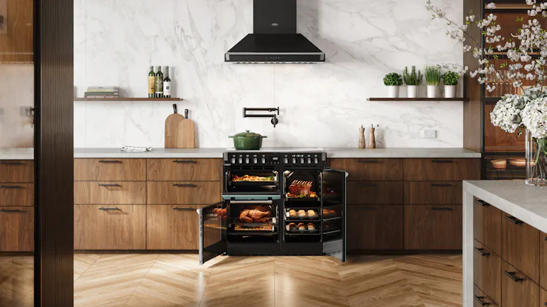 Belling Seafoam Blue range cooker displayed in a kitchen with both oven compartments illuminated Belling Seafoam Blue range cooker displayed in a kitchen with both oven compartments illuminated