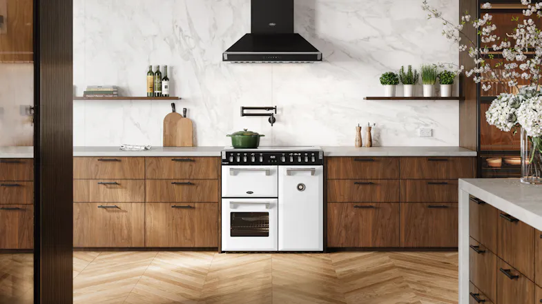 Wide kitchen scene featuring the freestanding oven positioned beneath a black rangehood Wide kitchen scene featuring the freestanding oven positioned beneath a black rangehood