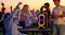 The speaker is propped on a table while a crowd parties around it The speaker is propped on a table while a crowd parties around it