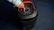 A view of a hand pressing on a button on the speaker A view of a hand pressing on a button on the speaker