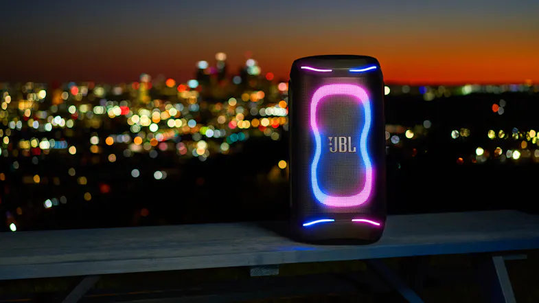 The speaker is propped on a table with a view of the skyline at the back The speaker is propped on a table with a view of the skyline at the back