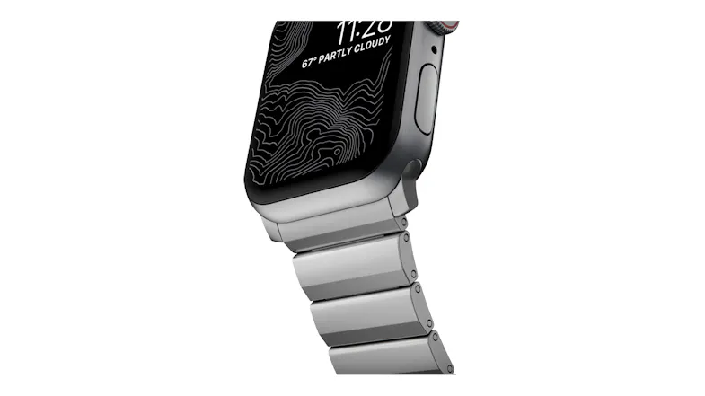 Close-up of a Nomad titanium Apple Watch case and brushed silver metal link band attachment Close-up of a Nomad titanium Apple Watch case and brushed silver metal link band attachment
