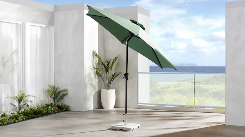 Pakiri round outdoor umbrella with a green polyester canopy tilted for adjustable shade Pakiri round outdoor umbrella with a green polyester canopy tilted for adjustable shade