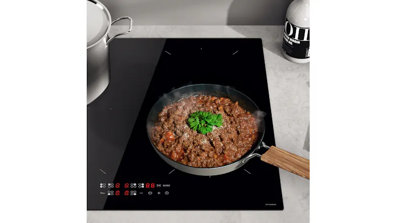 Pan of steaming cooked meat on a black induction cooktop with illuminated touch controls Pan of steaming cooked meat on a black induction cooktop with illuminated touch controls