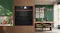 Built-in black Neff oven and steam drawer with bronze accents, integrated into modern wood cabinetry Built-in black Neff oven and steam drawer with bronze accents, integrated into modern wood cabinetry