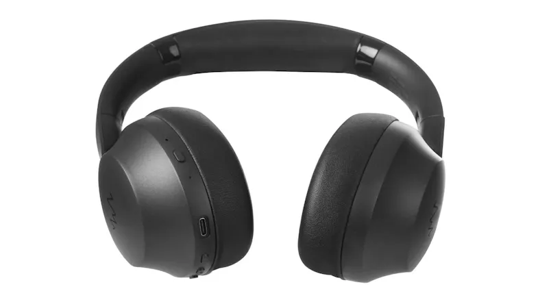 Close-up angled view of the left side of the black headphones, showing the ear cup shape and controls Close-up angled view of the left side of the black headphones, showing the ear cup shape and controls