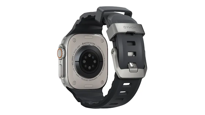 Rear view of Apple Watch Ultra showing back sensor array, rubber band, and titanium buckle engraved with Nomad Rear view of Apple Watch Ultra showing back sensor array, rubber band, and titanium buckle engraved with Nomad