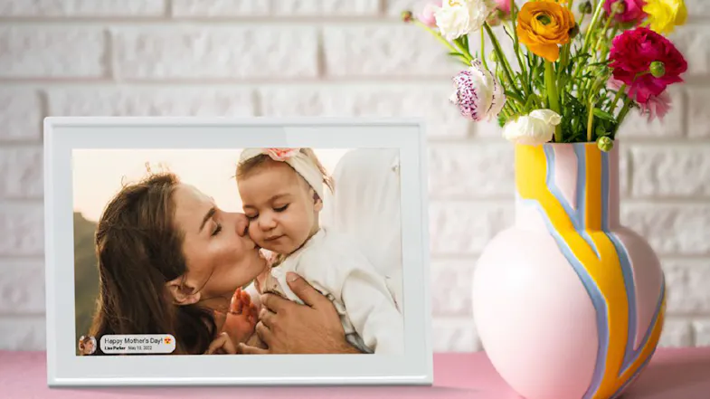 Jackson Frameo digital photo frame on a shelf with flowers and family photo displayed Jackson Frameo digital photo frame on a shelf with flowers and family photo displayed