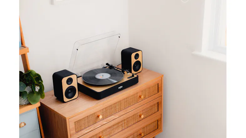 Close-up view featuring the turntable system on a wooden credenza Close-up view featuring the turntable system on a wooden credenza