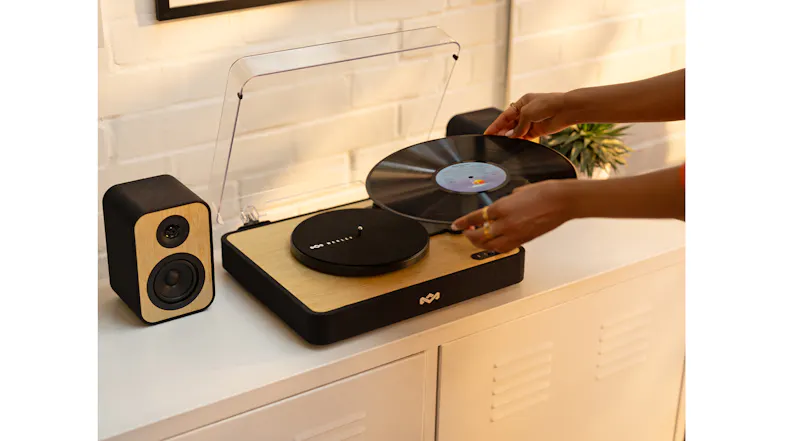 Action shot showcasing a hand placing a record on the platter Action shot showcasing a hand placing a record on the platter