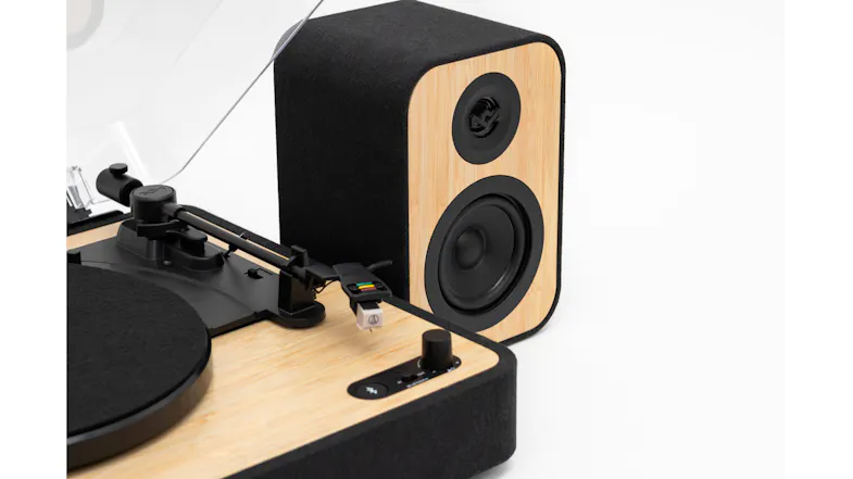 Close-up angle showing the turntable base next to a speaker Close-up angle showing the turntable base next to a speaker