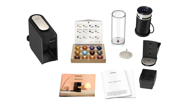 Deconstructed view of a coffee maker set showing capsules, frother, and manuals Deconstructed view of a coffee maker set showing capsules, frother, and manuals